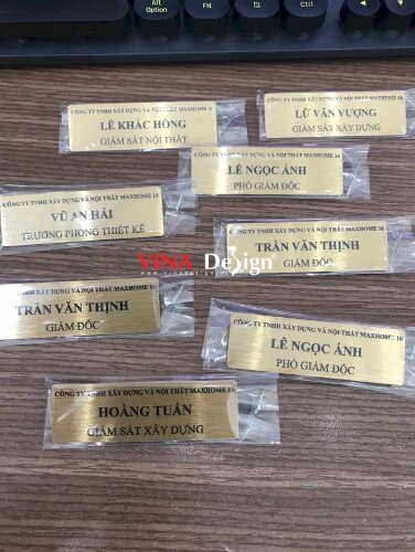 Làm bảng tên cài áo chức danh nhân sự cho công ty xây dựng & nội thất, bảng tên inox mặt nhôm xước màu vàng gold, in UV màu, gắn kim gài - VND820