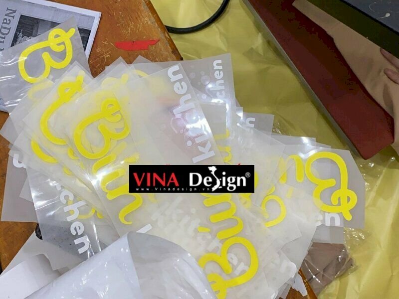 Sau khi file in được duyệt, hình sẽ được in lên tấm decal rồi gia công bế và cắt, sau đó rồi sử dụng máy ép nhiệt để tác động nhiệt độ cao lên Decal, giúp chúng dính chặt lên áo.